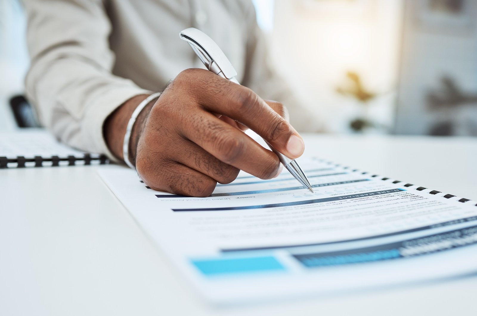 Hand, writing and marriage contract with pen for divorce, process or signature for assets on desk.
